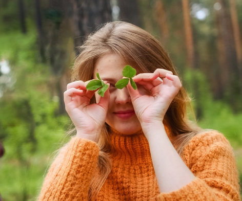 A girl holding green leaves